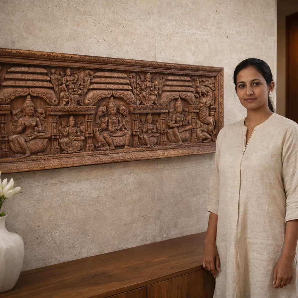 Woman standing next to a decorative wall panel with carvings in a room.

